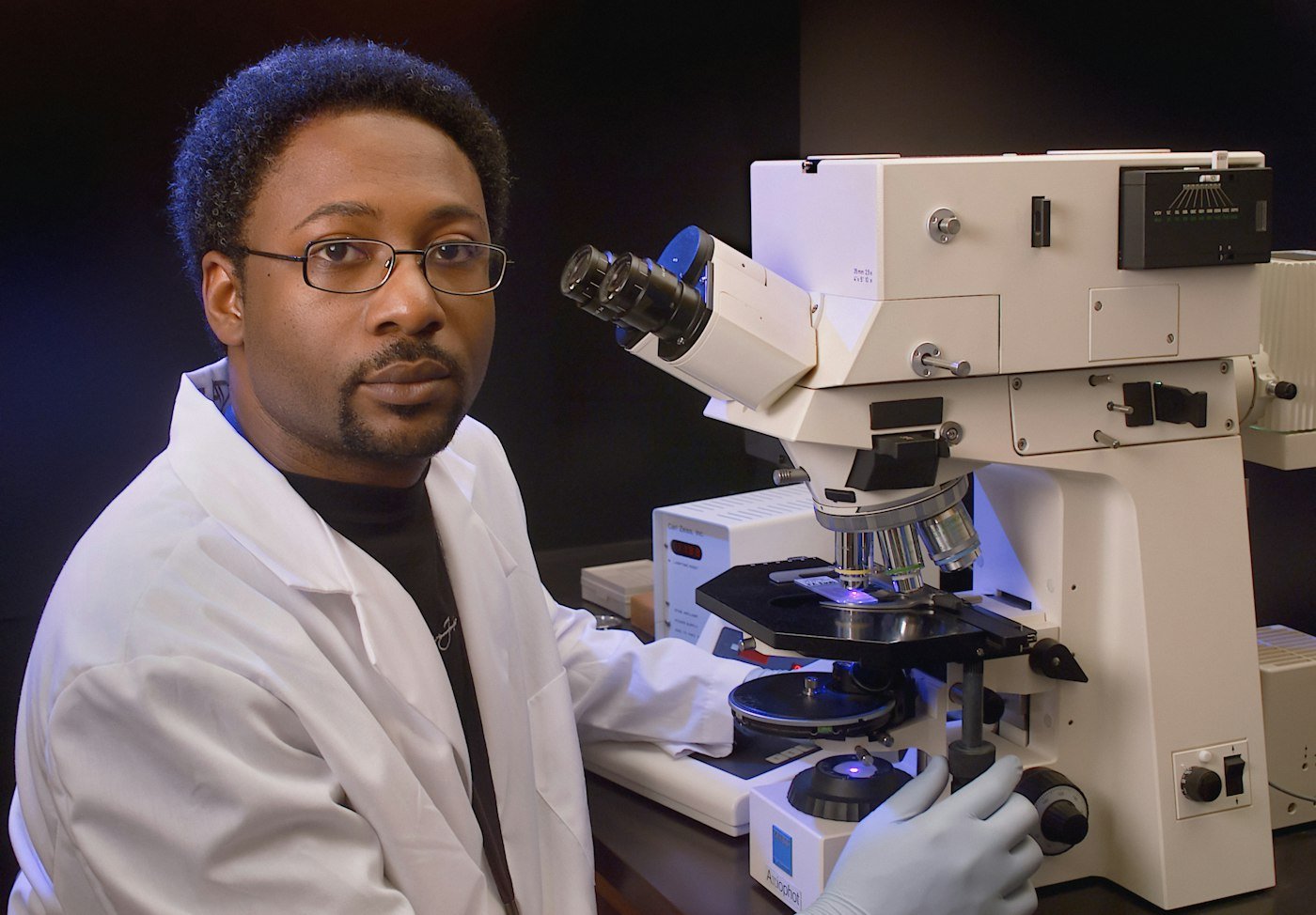 Laboratory scientist beside a microscope